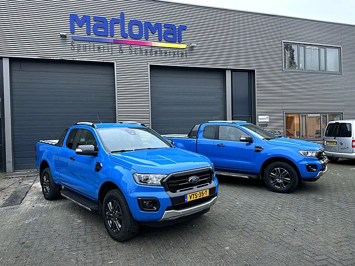 Blauwe pick-ups overgespoten in bedrijfskleur